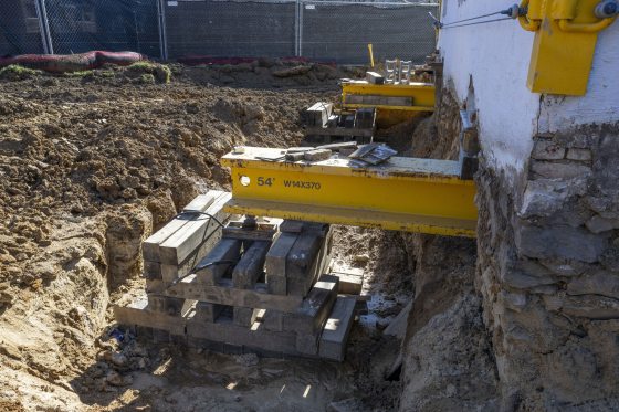 A large machine in the dirt used to move bulidings. 